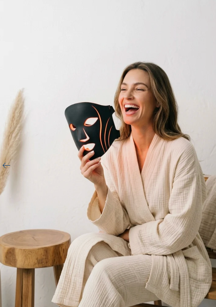 Woman holding LED face mask in robe